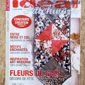 May include: A magazine cover titled "ideal Patchwork" with a close-up of a quilted bookmark. The bookmark features a floral pattern with red and white flowers on a black background. The magazine cover has French text.