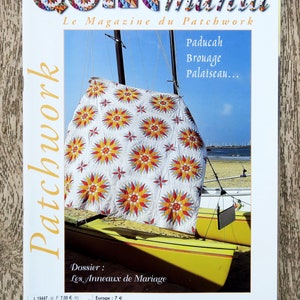 Op de afbeelding: Een tijdschriftcover voor Quiltmania, een patchworktijdschrift. De cover toont een kleurrijk quilt met een sterpatroon, tentoongesteld op een gele zeilboot. De titel van het tijdschrift staat in grote, kleurrijke letters. De tekst op de cover luidt "Quiltmania, Le Magazine du Patchwork, Paducah, Brouage, Palaiseau... Dossier: Les Anneaux de Mariage, Europe: 7€, Suisse: 12 FS, Canada: 10.95$, Bimestriel - Juillet/Août 2003 - N°36".