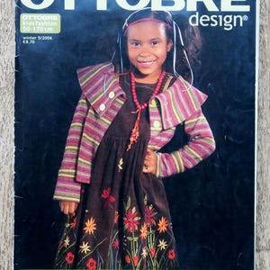 May include: Ottobre Design magazine cover. A girl in a brown floral embroidered dress and a striped jacket is featured. The magazine's title is "OTTOBRE design", with text indicating "kids fashion 50-170 cm" and "winter 5/2006".