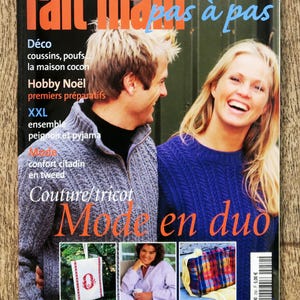 Puede incluir: Una portada de revista con el título "fait main" en naranja y rojo, con un hombre y una mujer sonriendo. La portada incluye texto en francés, con las palabras "Mode en duo" en naranja. La revista está fechada en noviembre de 2002.