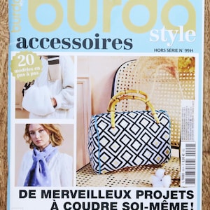 Op de afbeelding: Een tijdschriftcover voor "Burda Style Accessoires" met naaiprojecten. De cover toont een handtas met geometrisch patroon, een witte fluffy tas en een vrouw met een blauwe sjaal. Tekst bevat "20 modèles en pas à pas" en "De Merveilleux Projets à Coudre Soi-Même!".