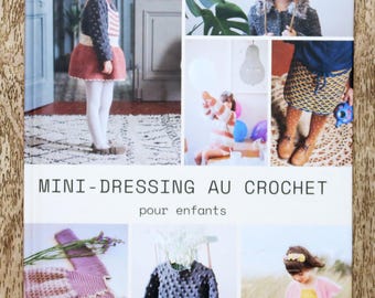 May include: A book cover titled "MINI-DRESSING AU CROCHET pour enfants" featuring images of children's crochet clothing. The cover includes photos of a girl in a crochet dress, a child in a hat, and other crochet garments. The text "3 8/10 ans" is also visible.