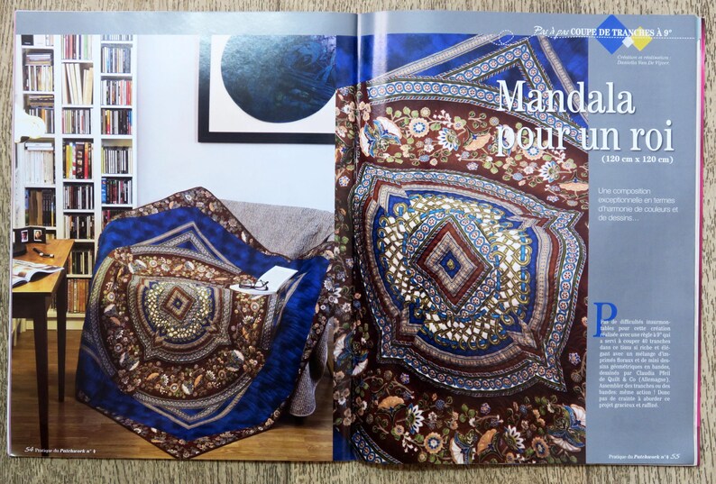 May include: A large, colorful mandala quilt with a brown, blue, and gold color scheme. The quilt is made up of many intricate geometric shapes and patterns. The quilt is called "Mandala pour un roi" and is 120 cm by 120 cm.