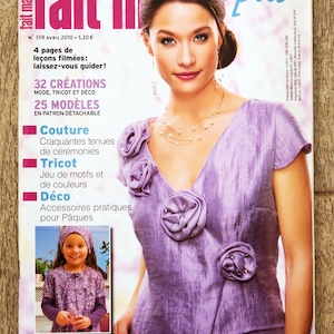 May include: A magazine cover featuring a woman in a lavender top with rosette embellishments. The magazine title is "fait main" with text in French. A smaller image shows a girl in a matching outfit. The cover includes text about fashion and crafts.