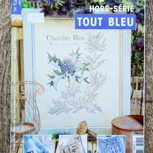 Könnte beinhalten: Ein Magazin-Cover mit dem Titel "De fil en aiguille" und dem Untertitel "Hors-Série" sowie dem Text "TOUT BLEU". Das Cover zeigt ein gerahmtes Stickdesign einer blauen Distel. Zusätzliche Bilder von Stickdesigns befinden sich unten.