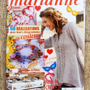 May include: A magazine cover featuring the title "les idées de marianne" in red, with a woman smiling. The cover includes images of crafts, embroidery, and a floral tablecloth. The text includes "60 RÉALISATIONS" and "Point de CROIX et TRICOT."