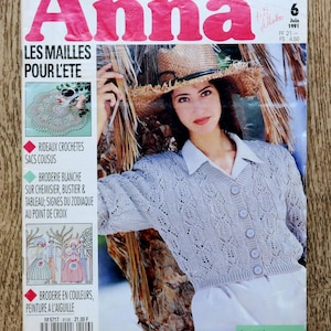 May include: A magazine cover with the title "Anna" in large red letters. The cover features a woman wearing a light gray cardigan and straw hat. Text includes "LES MAILLES POUR L'ETE" and "Juin 1991".