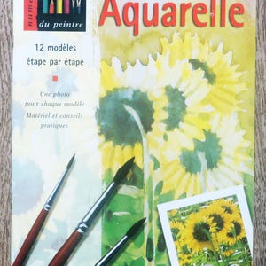 Peut inclure: Un livre intitulé "Aquarelle" avec une illustration de tournesol sur la couverture. Le livre fait partie d'une série appelée "Les cahiers du peintre" et présente 12 modèles de peinture à l'aquarelle avec des instructions étape par étape.