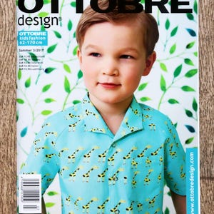 May include: Magazine cover showing a young boy in a light blue giraffe-print shirt. The magazine is titled "OTTOBRE design" and includes German text. It's a kids' fashion magazine, with sizes from 62-170 cm.