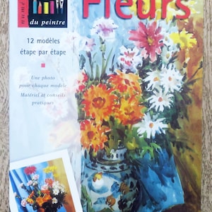 Może przedstawiać: Książka zatytułowana "Fleurs" z akwarelą przedstawiającą bukiet kwiatów w niebiesko-białym wazonie. Książka jest częścią serii "Les cahiers du peintre" i zawiera 12 modeli z instrukcjami krok po kroku.