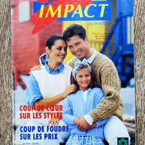 Puede incluir: Una portada de revista con una familia de tres personas que llevan suéteres de punto. La revista se titula "Impact de Phildar" y presenta el texto "Coup de Coeur sur les Styles" y "Coup de Foudre sur les Prix".