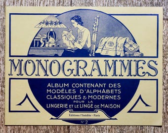 Peut inclure: Une couverture de livre vintage avec un schéma de couleurs bleu et jaune. Le titre est "MONOGRAMMES" et le texte ci-dessous indique "ALBUM CONTENANT DES MODELES D'ALPHABETS CLASSIQUES & MODERNES POUR LA LINGERIE ET LE LINGE DE MAISON. Editions l'Inédite - Paris N° 2".