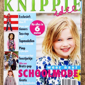 May include: A magazine cover with the title "KNIPPLE" in large green letters and the word "idee" in pink script. The cover features a smiling girl with blonde hair and a blue floral top. Text includes "SCHOOLMODE" and other fashion-related phrases.