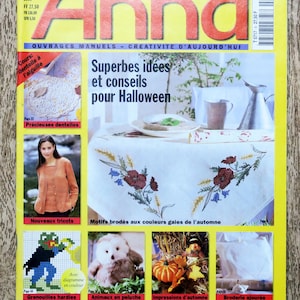 May include: A magazine cover featuring a colorful illustration of a table setting with embroidered autumn leaves and flowers. The magazine is titled "Anna" and the cover text reads "Superbes idées et conseils pour Halloween".
