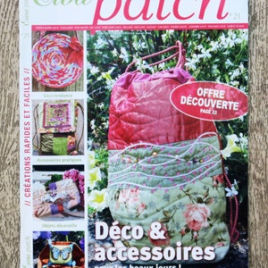 Op de afbeelding: Een tijdschriftcover met een roze en groene trekkoordtas met bloemenstof. Het tijdschrift heet "Ewa Patch" en de tekst op de omslag luidt "Déco & accessoires pour les beaux jours!" Het tijdschrift is nummer 21.