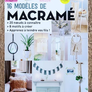 May include: A magazine cover featuring 16 macrame projects. The cover features a variety of macrame projects, including wall hangings, plant hangers, and a macrame pillow. The cover also includes the text "16 Modèles de Macramé" and "Techniques et conseils pour tous les niveaux!"
