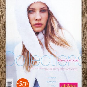 Puede incluir: Una portada de revista con una mujer que lleva un abrigo y un sombrero de piel sintética blanca. El texto de la portada dice "Collections hiver 2005-2006" y "Des faux blancs cosy... aux touleurs jouées en toute liberté... découvrez nos 4 grands courants de mode!" La revista se titula "Phildar" y enumera los siguientes estilos: "Candide", "Glamour", "Folk", y "Baroque".