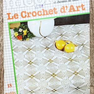 Peut inclure: Un livre de modèles de crochet vintage avec une nappe en crochet blanc sur la couverture. Le livre est intitulé "Le Crochet d'Art" et présente 18 modèles de crochet pour nappes et chemins de table rectangulaires.