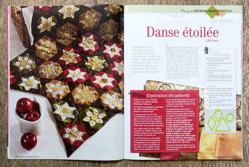 May include: A colorful quilt with a star pattern, made with fabric scraps. The quilt is called "Danse &eacute;toil&eacute;e" and is 84 cm wide. The quilt is displayed on a table with apples in a white bowl.