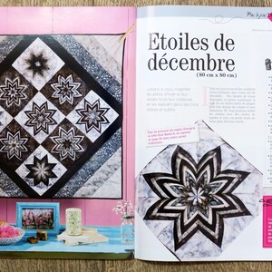 May include: A magazine page featuring a quilt pattern with black and white stars. The quilt is 32 inches by 32 inches. The magazine page also includes a larger star pattern with a white background and black and gray accents. The text on the page reads "Etoiles de d&eacute;cembre (80 cm x 80 cm)" and "Description du Projet".