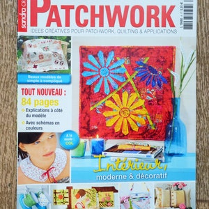 Può includere: Una copertina di rivista per Patchwork, una pubblicazione per gli appassionati di patchwork e quilting. La copertina presenta una trapunta colorata con un motivo floreale e il testo "Interieur, moderne & decoratif".