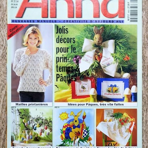 May include: A magazine cover featuring a woman wearing a white crocheted sweater and a bunny rabbit with a wreath of greenery. The magazine is titled "Anna" and the cover text reads "Jolis decors pour le printemps & Pâques" which translates to "Pretty decorations for spring and Easter".