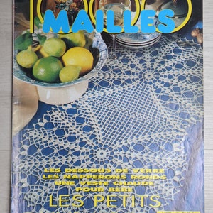 Puede incluir: Una portada de revista 1000 Mailles de octubre de 1992 con un tapete de ganchillo blanco sobre una superficie azul, un cuenco de cítricos verdes y amarillos y una copa de vino blanco. El texto incluye 1000 Mailles y Les Petits Ouvrages.
