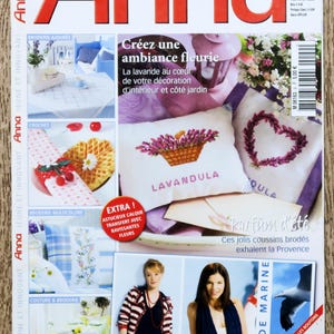 May include: A magazine cover featuring a lavender-themed embroidery project. The cover text reads "Créez une ambiance fleurie" and "Parfum d'été". The magazine is titled "Anna" and features a photo of a woman wearing a striped shirt and jeans.