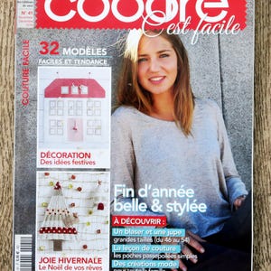 Op de afbeelding: Een magazinecover met de titel "coudre est facile" in rood en wit. De cover toont een vrouw en tekst die naaiprojecten promoot, waaronder "32 modèles faciles et tendance" en "Fin d'année belle & stylée". Het tijdschrift heet "Le magazine de couture créative".
