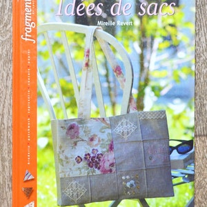 Può includere: Un libro intitolato "Idées de sacs" di Mireille Revert, che presenta una borsa a tracolla con motivo floreale su una sedia bianca. La copertina del libro ha una spina dorsale arancione brillante con la parola "fragments" in testo bianco.