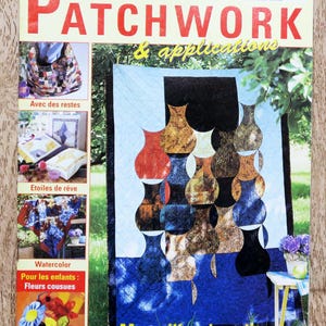 Op de afbeelding: De omslag van een tijdschrift getiteld "PATCHWORK & applications" toont een quiltontwerp met vaasvormige patronen in tinten rood, bruin en blauw. Het tijdschrift toont ook andere patchworkprojecten en de tekst "Merveilles de quilts".