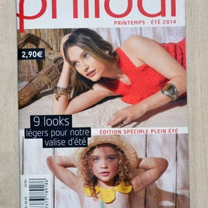 May include: A magazine cover for Phildar featuring a woman wearing a red sleeveless top and a girl wearing a straw hat and a light pink dress with a yellow flower design. The magazine cover text reads "Phildar, Printemps - Été 2014, 9 looks légers pour notre valise d'été, Édition spéciale plein été".