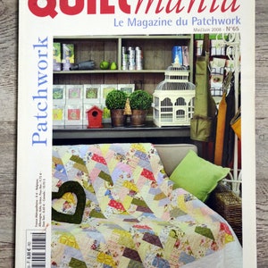 Op de afbeelding: Een tijdschriftcover voor Quiltmania, een patchworktijdschrift. De cover toont een kleurrijk patchworkdeken op een bank met een vogelkooi en andere woonaccessoires op de achtergrond. De titel van het tijdschrift is "Quiltmania" en de ondertitel is "Le Magazine du Patchwork". Het nummer van het tijdschrift is 65 en de datum is Mei/Juni 2008.
