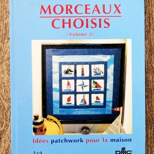 Op de afbeelding: Een lichtblauw boek getiteld "MORCEAUX CHOISIS" (Deel 2) van Claude Favre. De omslag toont een patchworkontwerp met zeilboten en een vuurtoren. De tekst "Idées patchwork pour la maison" is ook zichtbaar.