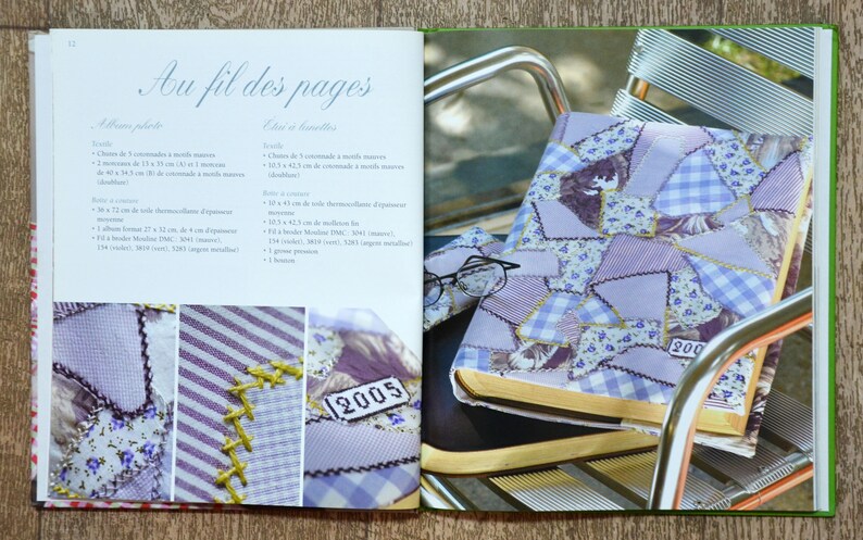 May include: A purple and white patchwork fabric book cover with the number "2005" stitched on it. The book is sitting on a metal chair.