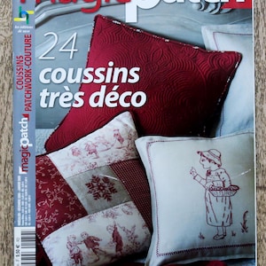 Pode incluir: Uma capa de revista com um almofada de patchwork vermelho, branco e bege com um design floral. A revista chama-se "magicpatch" e o texto da capa diz "24 coussins très déco" e "Faciles et rapides à réaliser".