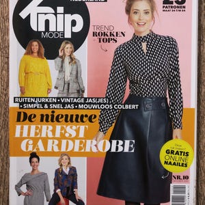 May include: A magazine cover featuring the title "Trip Mode" with the text "De nieuwe Herfst Garderobe" and "23 Patronen Maat 34 t/m 54". The cover features a woman wearing a black and white patterned blouse and a black skirt.