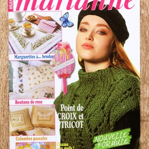 Könnte beinhalten: Magazin-Cover mit einer Frau in einem schwarzen Barett und einem grünen Strickoberteil. Der Magazintitel lautet "les idées de marianne" in Pink. Text enthält "Point de CROIX et TRICOT" und "NOUVELLE FORMULE".