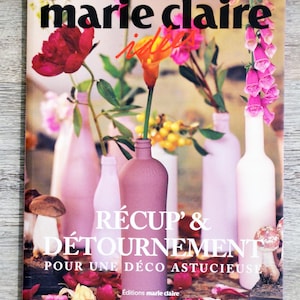 Peut inclure: Une couverture de magazine Marie Claire Idées, avec le titre "Récup' & Détournement Pour Une Déco Astucieuse" et une photo de fleurs dans des bouteilles de différentes couleurs.