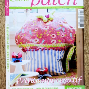 Peut inclure: Couverture du magazine "Ewa patch" avec le titre en rose et vert. La couverture présente un grand coussin décoratif avec un motif floral rose, des rayures bleues et des accents verts. Le texte "Printemps créatif" est également visible.