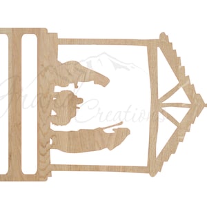 May include: Wooden cutout of a nativity scene with a star on top. The scene includes Mary, Joseph, and baby Jesus in a manger.