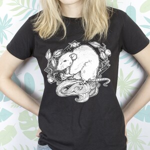 May include: Black t-shirt with a white graphic of a rat with a crescent moon and stars in the background.