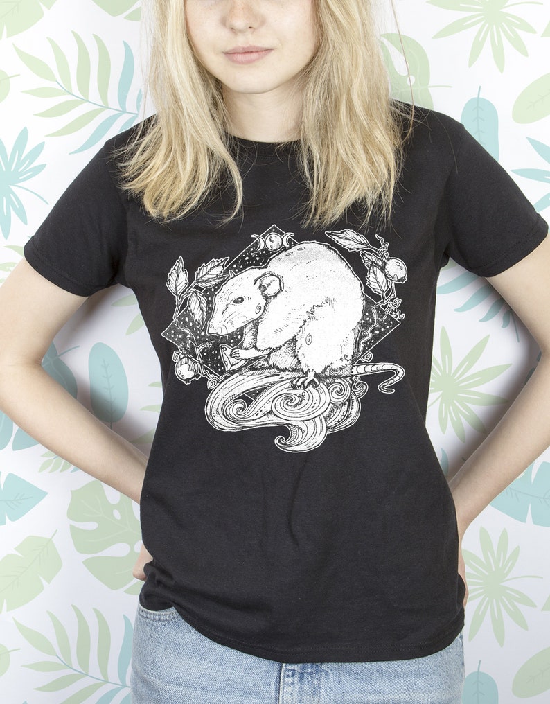 May include: Black t-shirt with a white graphic of a rat with a crescent moon and stars in the background.