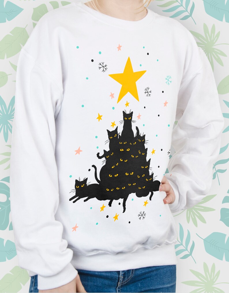 May include: White sweatshirt with a black cat Christmas tree design. The cats are stacked on top of each other, forming a tree shape. A yellow star is at the top of the tree.