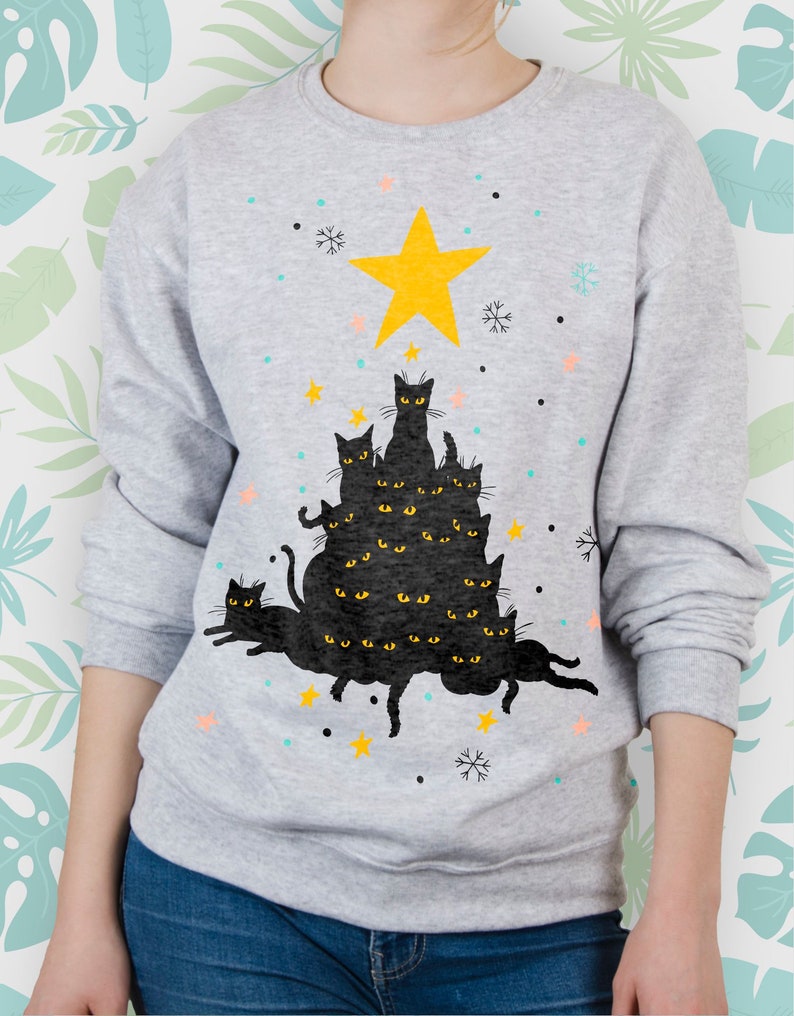 May include: A gray sweatshirt with a black cat Christmas tree design. The tree is made up of multiple black cats stacked on top of each other, with a yellow star on top. The cats have yellow eyes and are arranged in a tree shape.