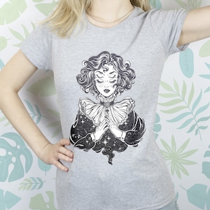 May include: Gray t-shirt with a black and white illustration of a woman with closed eyes and a star-filled background.