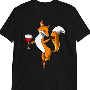 May include: A black t-shirt with a cartoon image of a fox holding a glass of red wine. The fox is orange and white with a bushy tail.