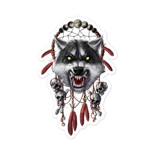 May include: A sticker featuring a detailed illustration of a wolf's head with glowing yellow eyes and bared teeth. The wolf is set against a dreamcatcher design with skulls, feathers, and a crescent moon phase. The sticker has a white border.