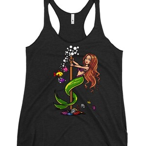 Könnte beinhalten: Ein schwarzes Tanktop mit einem Motiv einer Meerjungfrau mit roten Haaren und einem grünen Schwanz, die an einem Pfosten festhält, aus dem Blasen aufsteigen. Es gibt auch bunte Fische und Muscheln um die Meerjungfrau herum.