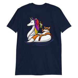 May include: A navy blue t-shirt with a graphic of a fox riding a unicorn float in a pool. The fox is holding a cocktail.